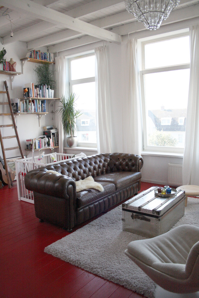 Photo of an eclectic living room in Amsterdam with red floors.