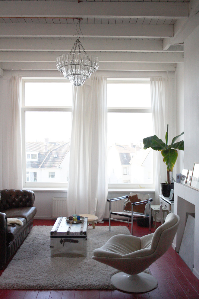 Inspiration for a bohemian living room in Amsterdam with red floors.