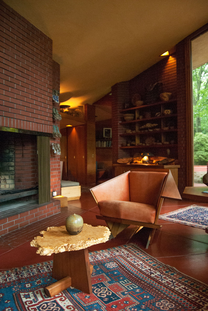 Источник вдохновения для домашнего уюта: гостиная комната в стиле модернизм с стандартным камином, фасадом камина из кирпича и красным полом
