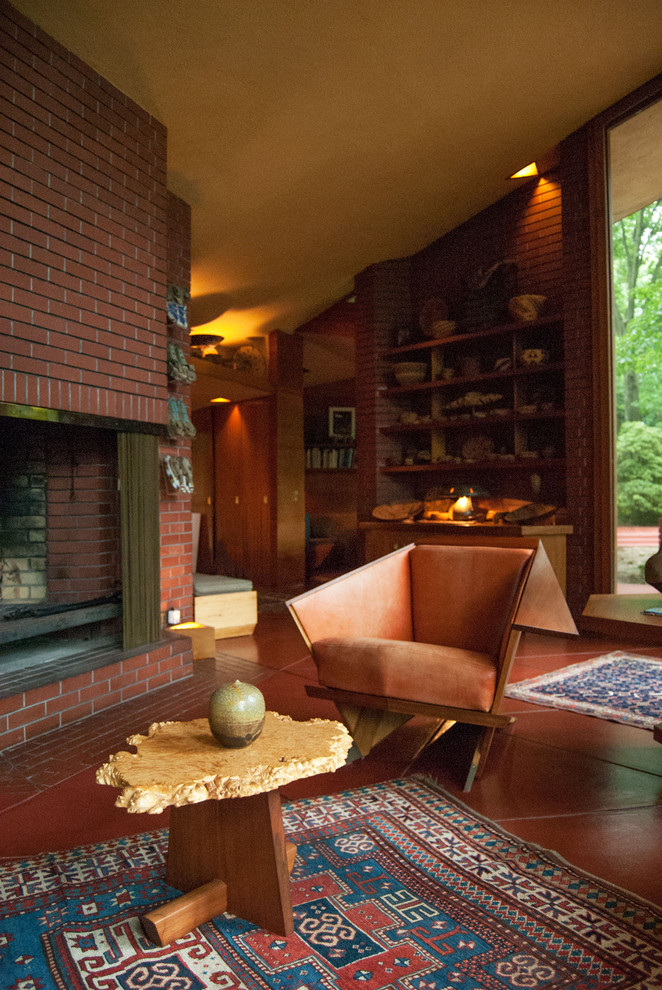 Living room - modern red floor living room idea in Cleveland with a standard fireplace and a brick fireplace