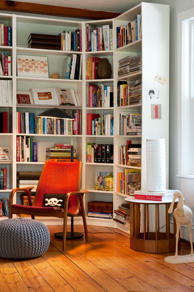Idée de décoration pour un salon design avec une bibliothèque ou un coin lecture et un sol en bois brun.
