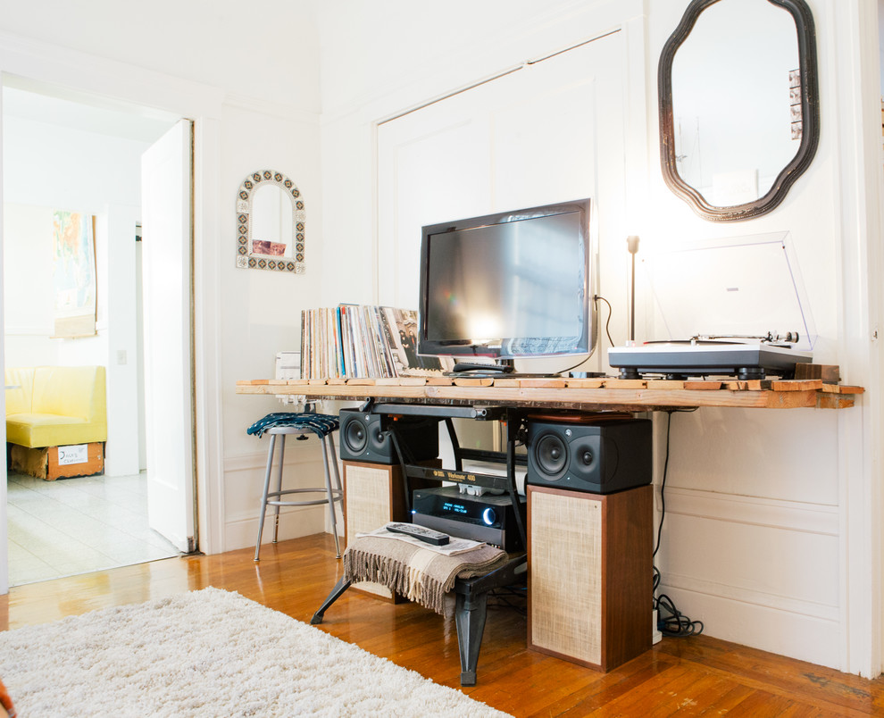 Foto di un soggiorno boho chic con TV autoportante, pareti bianche e pavimento in legno massello medio