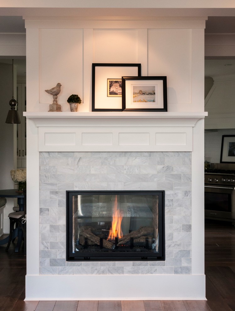 バンクーバーにある高級な広いシャビーシック調のおしゃれなLDK (白い壁、無垢フローリング、両方向型暖炉、石材の暖炉まわり) の写真