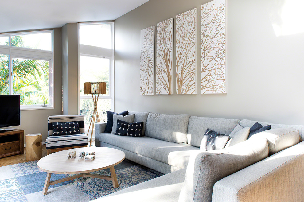 Living room - contemporary formal and open concept medium tone wood floor living room idea in Sydney with gray walls and a tv stand