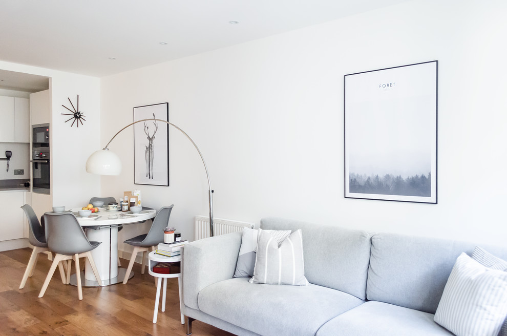 Living room library - small scandinavian open concept laminate floor living room library idea in London with white walls, no fireplace and a tv stand