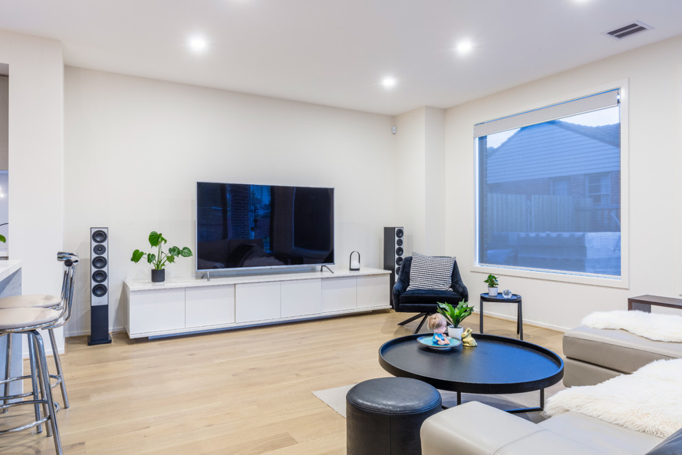 Example of a mid-sized trendy open concept light wood floor living room design in Melbourne with white walls, no fireplace and a tv stand