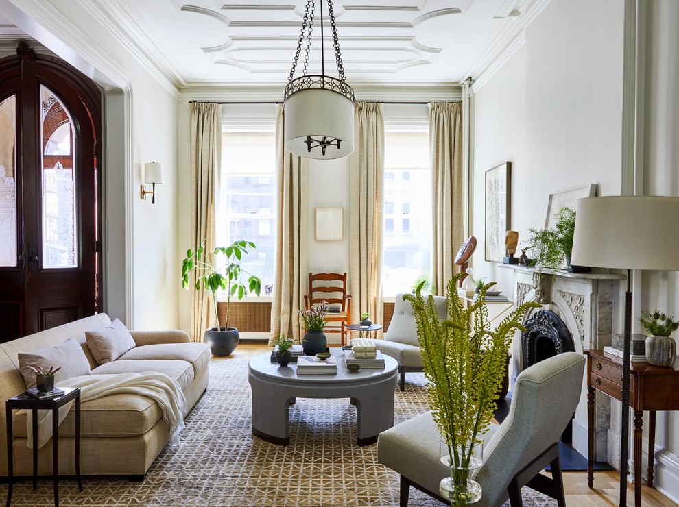 Example of a transitional medium tone wood floor and brown floor living room design in New York with white walls