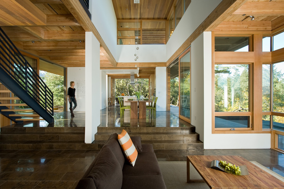 Foto di un soggiorno minimalista aperto e di medie dimensioni con pareti bianche, pavimento in pietra calcarea e pavimento marrone