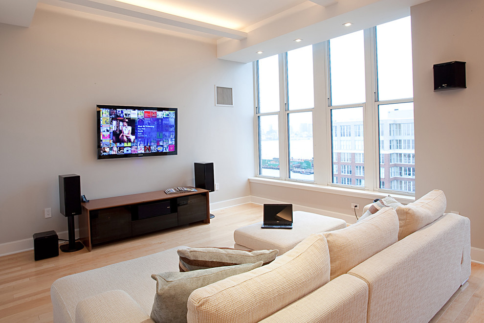 Example of a mid-sized trendy formal and open concept light wood floor and beige floor living room design in New York with beige walls, no fireplace and a wall-mounted tv