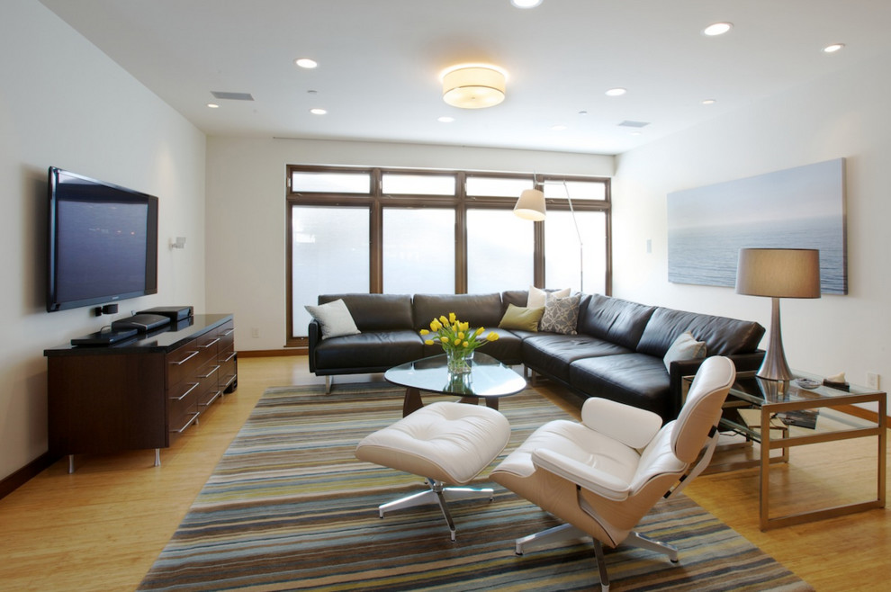 Cette photo montre un salon moderne ouvert avec un mur blanc, parquet en bambou et un téléviseur fixé au mur.