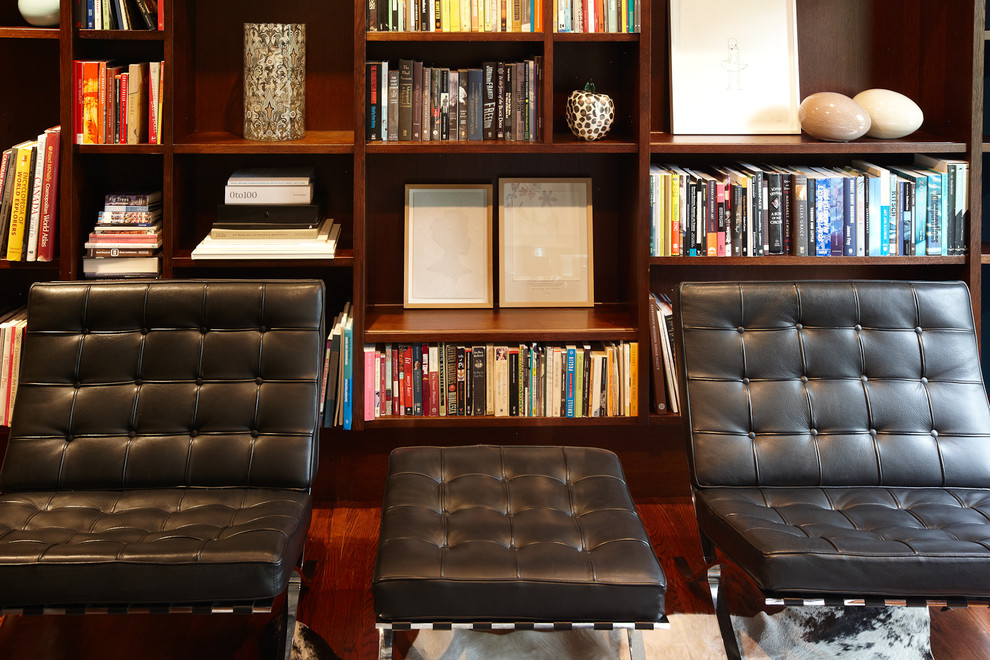 Exemple d'un petit salon tendance ouvert avec une bibliothèque ou un coin lecture, un mur bleu, un sol en bois brun et aucun téléviseur.