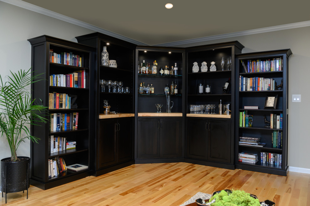 Ispirazione per un soggiorno tradizionale di medie dimensioni e chiuso con libreria, pareti beige, pavimento in legno massello medio e pavimento beige