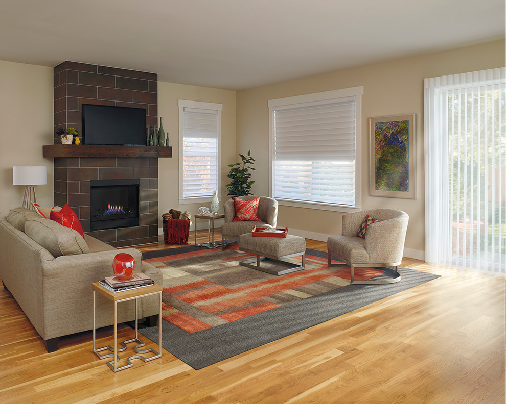 This is an example of a large classic open plan living room in San Diego with medium hardwood flooring, a standard fireplace, a tiled fireplace surround and a freestanding tv.