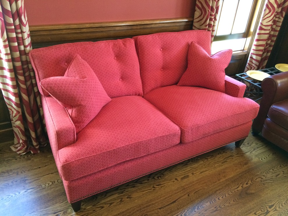 Immagine di un soggiorno tradizionale di medie dimensioni e chiuso con sala formale, pareti rosa, pavimento in legno massello medio, nessun camino, nessuna TV e pavimento marrone