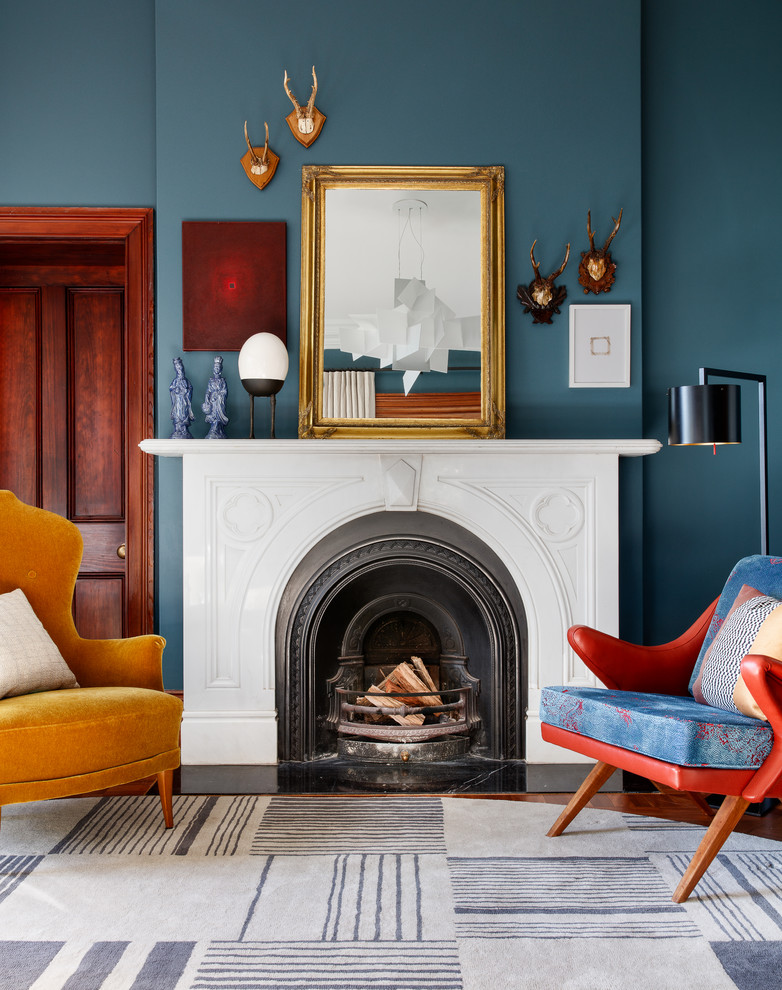 Klassisches Wohnzimmer mit blauer Wandfarbe, braunem Holzboden, Kaminumrandung aus Stein und braunem Boden in Sydney