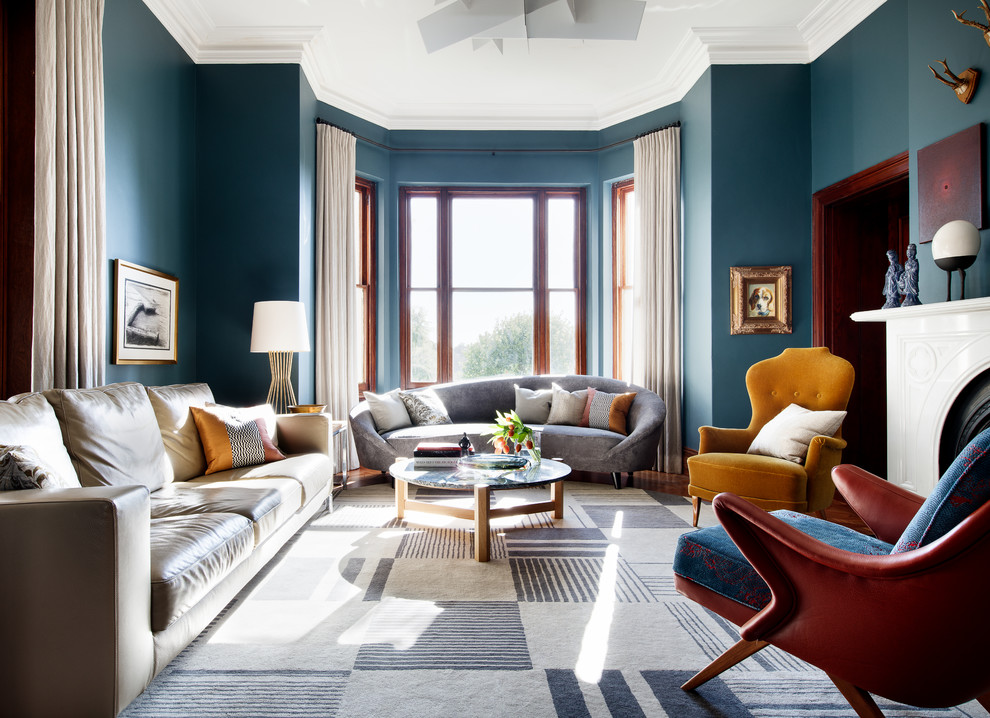 Idee per un soggiorno chic chiuso con pareti blu, pavimento in legno massello medio, cornice del camino in pietra, pavimento marrone, sala formale e camino classico