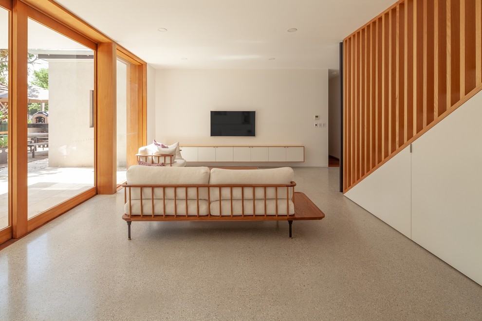 シドニーにある高級な中くらいなコンテンポラリースタイルのおしゃれなLDK (白い壁、コンクリートの床、暖炉なし、壁掛け型テレビ、白い床) の写真