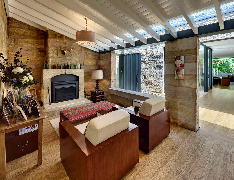 Idee per un soggiorno rustico con pareti marroni, pavimento in legno massello medio, camino classico e pavimento marrone