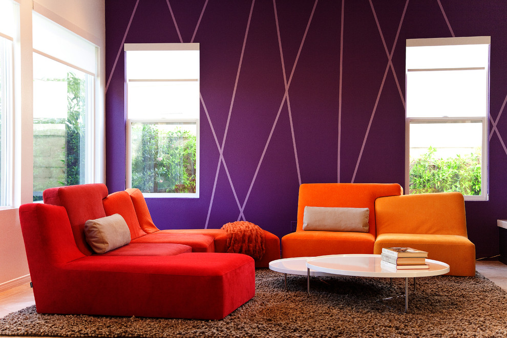 На фото: гостиная комната в стиле модернизм с фиолетовыми стенами с