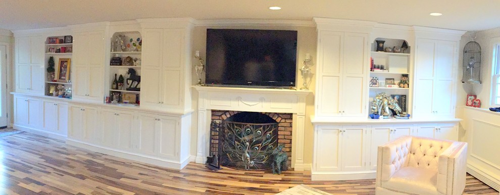 Esempio di un soggiorno chic di medie dimensioni con pareti beige, pavimento in legno massello medio, camino classico, cornice del camino in mattoni e TV a parete