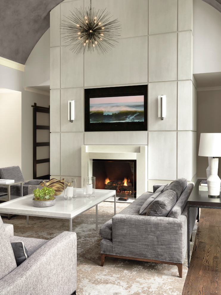 Пример оригинального дизайна: гостиная комната в стиле неоклассика (современная классика) с белыми стенами, паркетным полом среднего тона, стандартным камином, телевизором на стене и коричневым полом