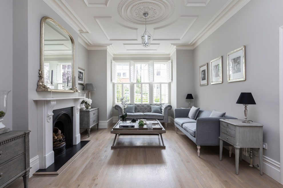 Großes, Abgetrenntes Klassisches Wohnzimmer mit grauer Wandfarbe, hellem Holzboden, braunem Boden, Kamin und Kaminumrandung aus Stein in London