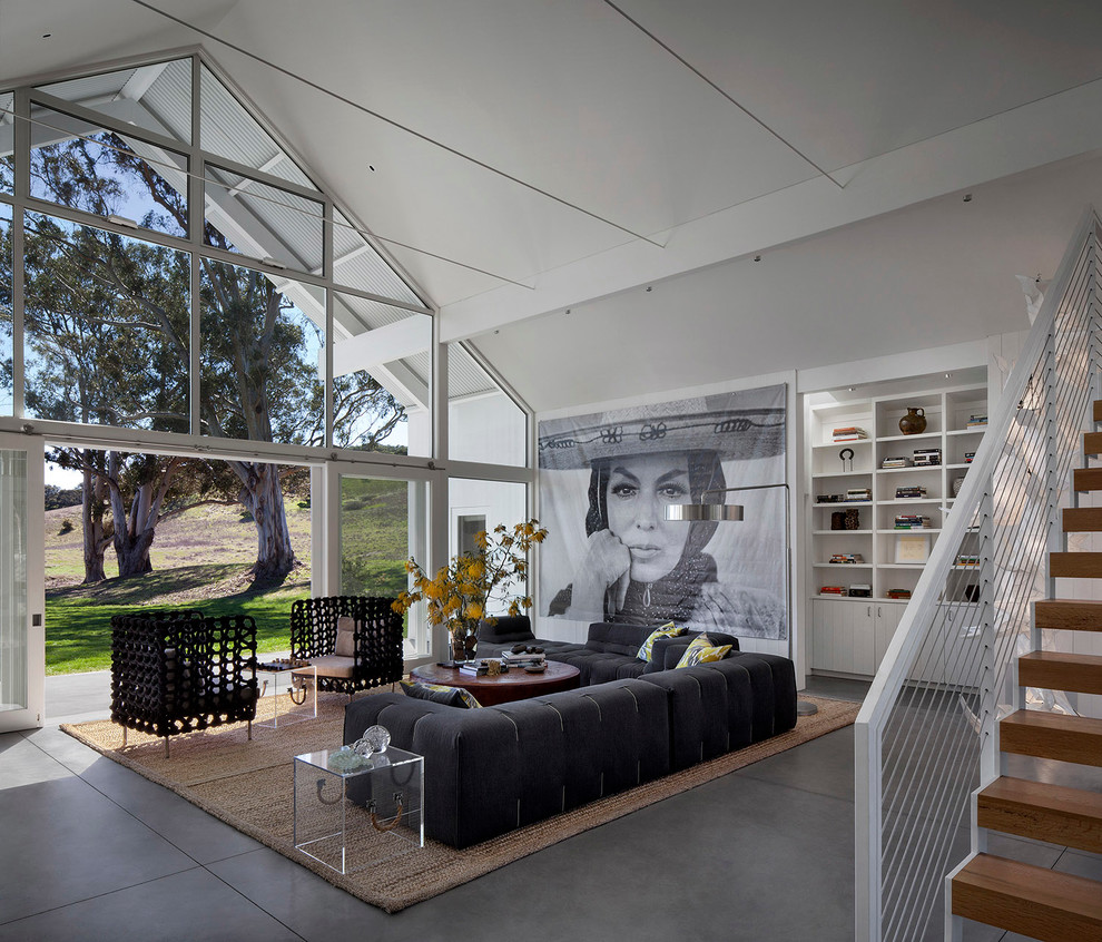 Immagine di un soggiorno minimal aperto con pareti bianche e pavimento in cemento