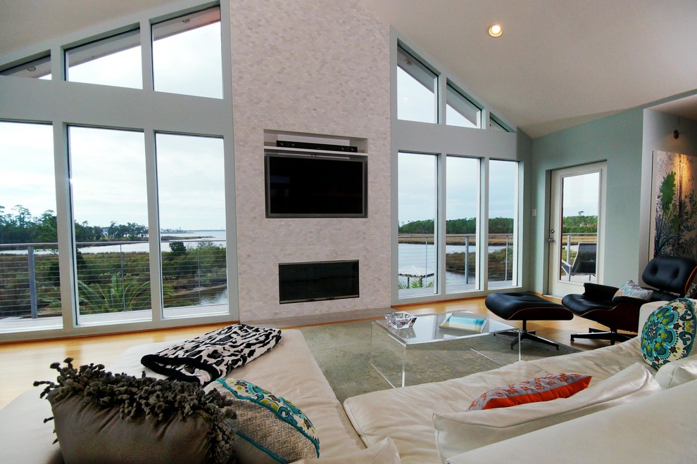 Idee per un grande soggiorno stile marino aperto con pavimento in bambù, cornice del camino piastrellata e TV a parete