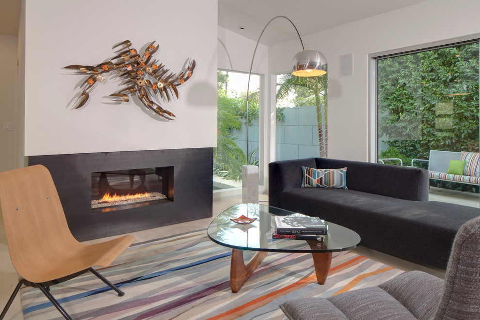 This is an example of a modern living room in Los Angeles with a metal fireplace surround.