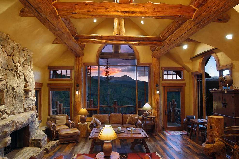 Example of a mountain style living room design in Vancouver with yellow walls and a stone fireplace