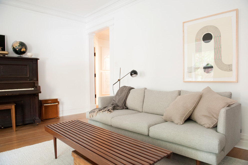 This is an example of a scandi living room in Los Angeles with white walls, medium hardwood flooring and brown floors.