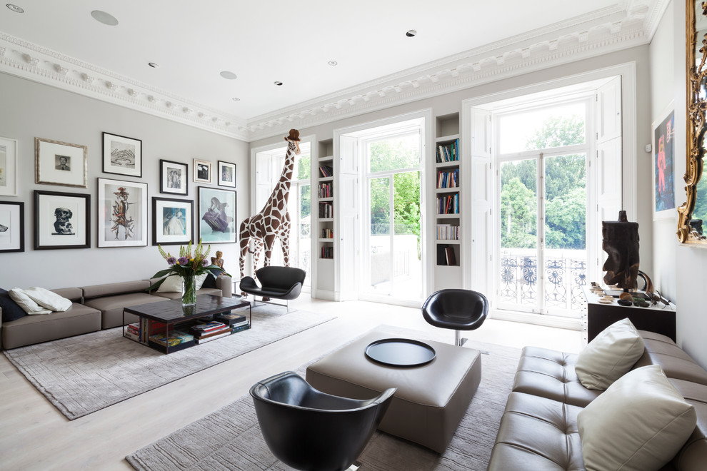 Photo of a large modern formal open plan living room in London with grey walls and light hardwood flooring.