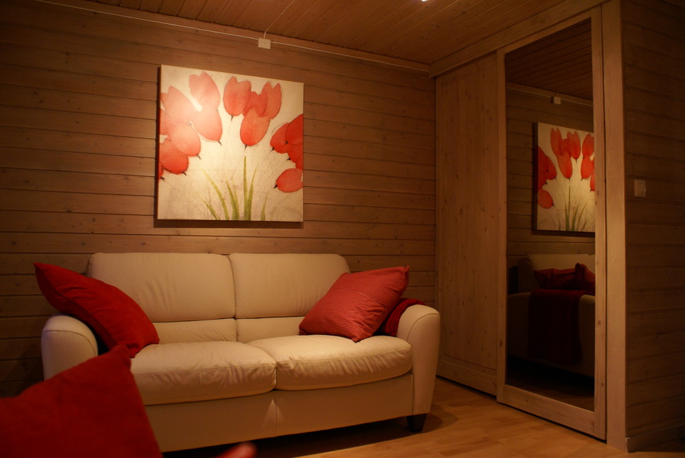 Foto de salón abierto actual pequeño con paredes grises, estufa de leña, marco de chimenea de madera, televisor independiente y suelo de madera clara