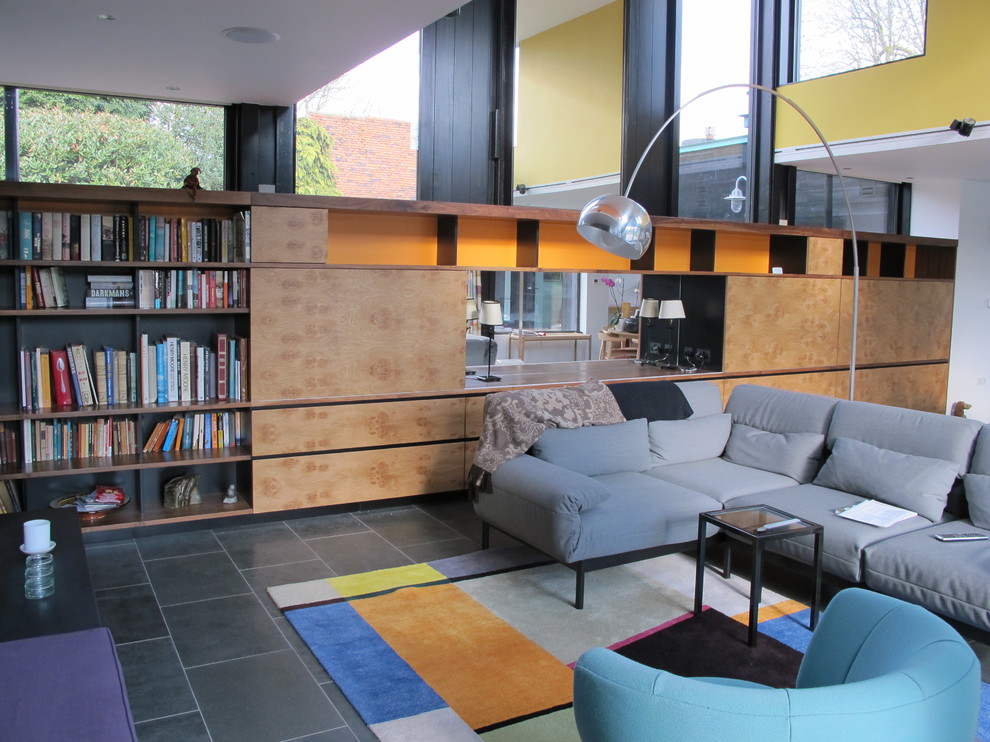 Diseño de biblioteca en casa abierta minimalista pequeña sin chimenea y televisor con paredes blancas y suelo de pizarra