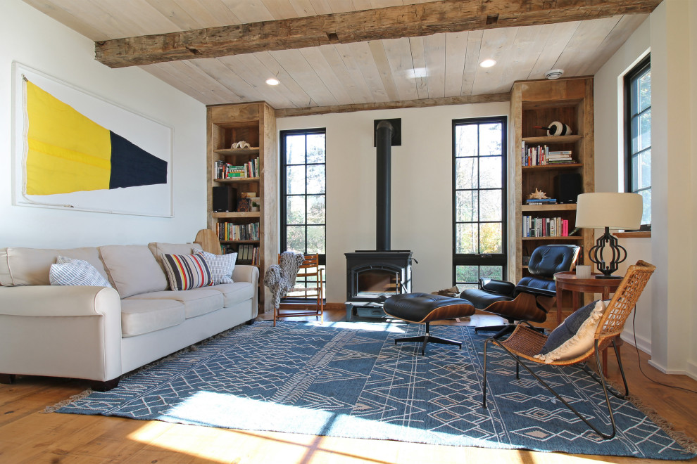 Ispirazione per un soggiorno stile marino di medie dimensioni e aperto con pareti bianche, pavimento in legno massello medio, stufa a legna, nessuna TV e pavimento marrone