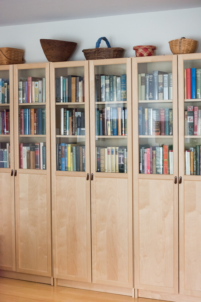 Ejemplo de biblioteca en casa cerrada actual de tamaño medio sin chimenea y televisor con paredes blancas, suelo de bambú y suelo beige
