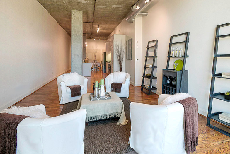 Großes, Repräsentatives, Fernseherloses, Offenes Modernes Wohnzimmer ohne Kamin mit weißer Wandfarbe und braunem Holzboden in Houston