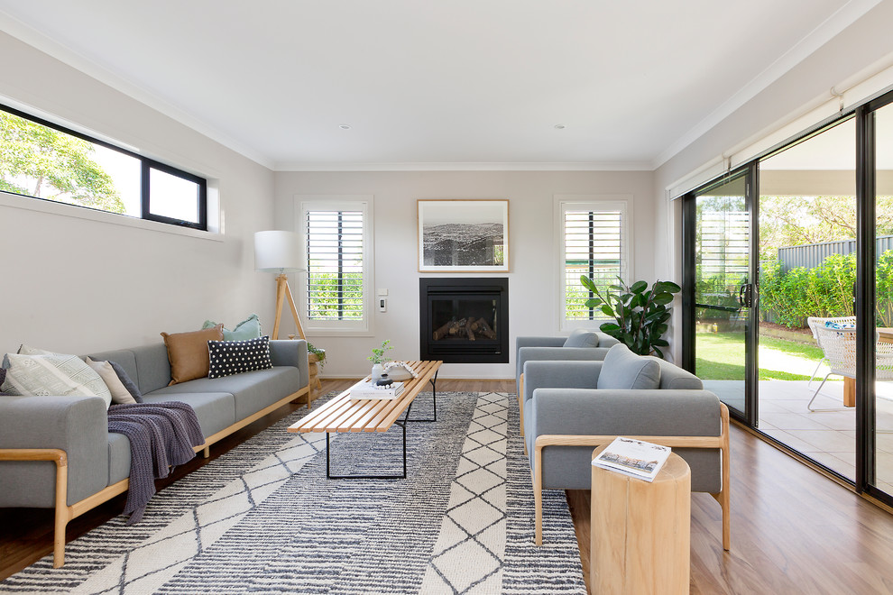 Repräsentatives, Fernseherloses Nordisches Wohnzimmer mit braunem Holzboden, Kamin und braunem Boden in Sydney