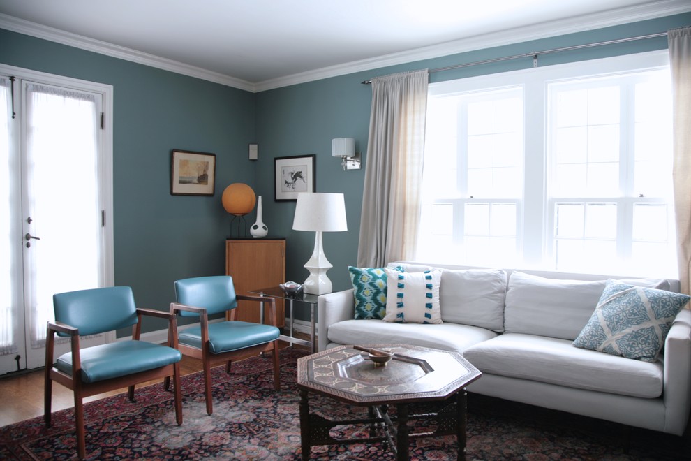 Esempio di un soggiorno chic di medie dimensioni e chiuso con sala formale, pareti blu, pavimento in legno massello medio, nessun camino e nessuna TV