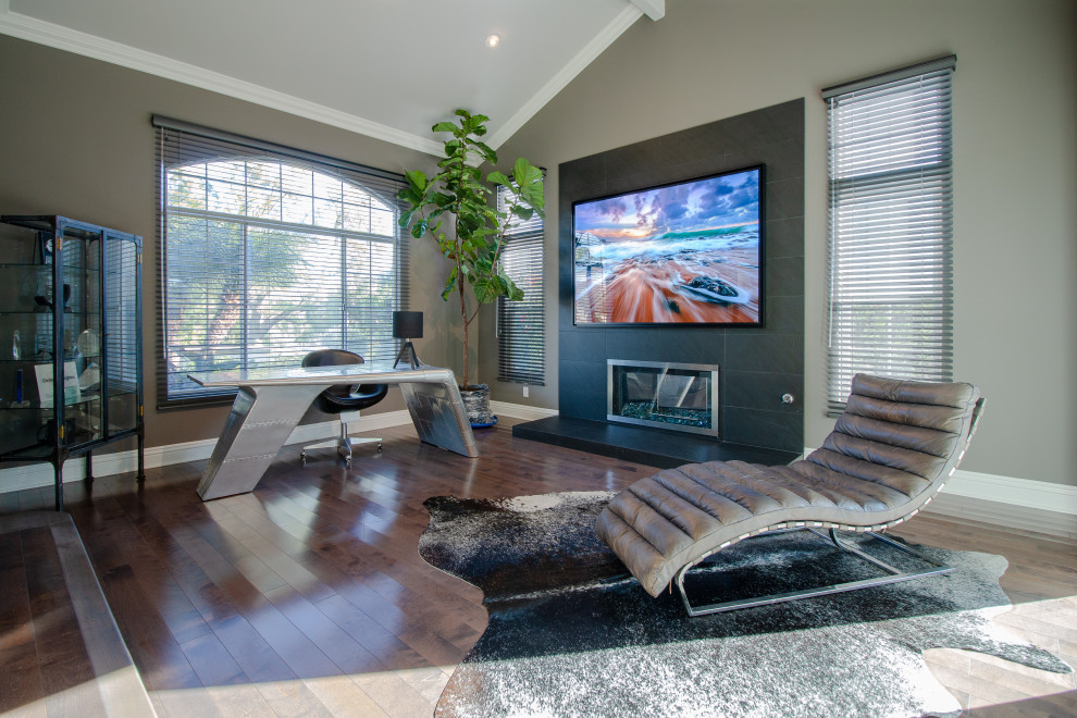 Photo of a medium sized industrial open plan living room in Los Angeles with grey walls, dark hardwood flooring, a ribbon fireplace, a metal fireplace surround, a wall mounted tv and brown floors.