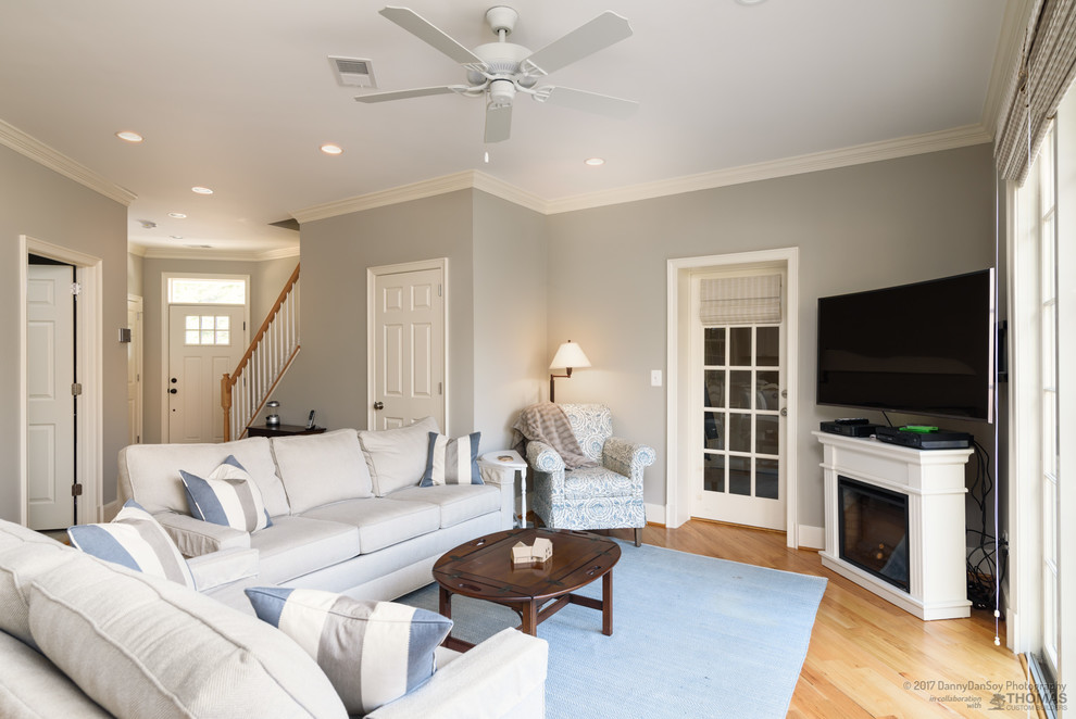 Пример оригинального дизайна: большая изолированная гостиная комната в классическом стиле с серыми стенами, светлым паркетным полом, угловым камином, фасадом камина из дерева, отдельно стоящим телевизором и коричневым полом