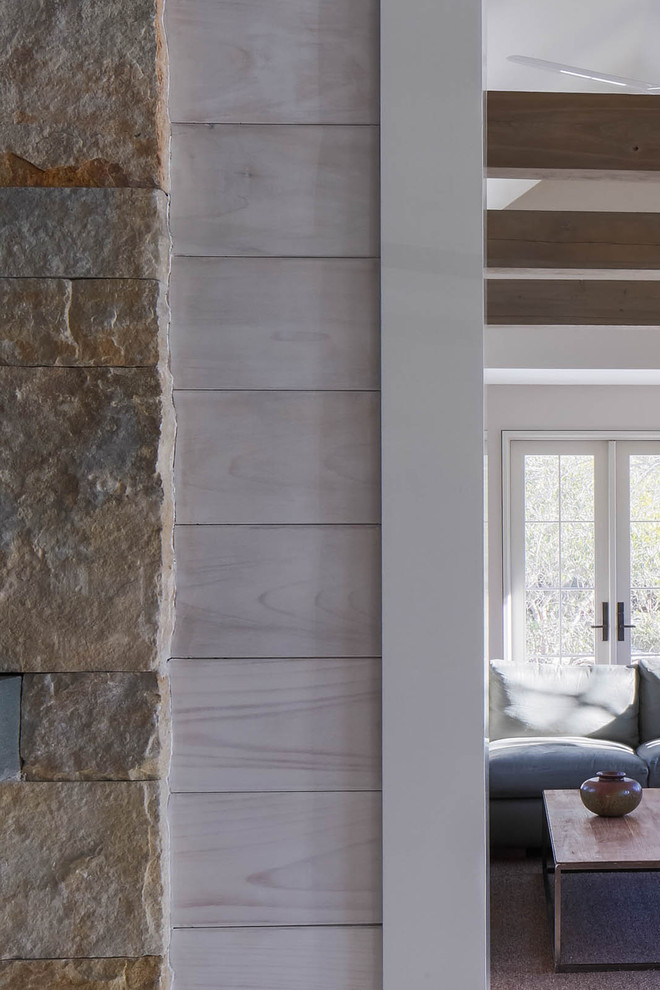 Источник вдохновения для домашнего уюта: открытая гостиная комната в стиле модернизм с с книжными шкафами и полками и фасадом камина из камня