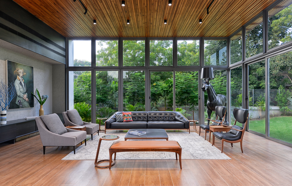 Esempio di un soggiorno design chiuso con sala formale, pavimento in legno massello medio e pavimento marrone