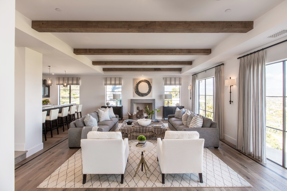 Offenes Klassisches Wohnzimmer mit weißer Wandfarbe, dunklem Holzboden, Kamin und braunem Boden in Orange County