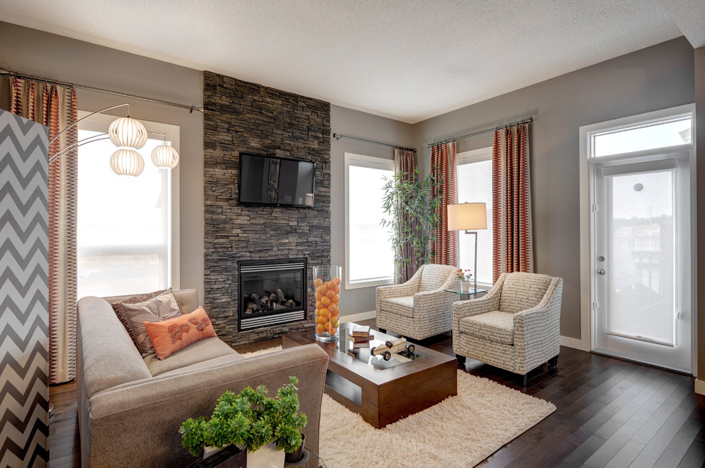 Photo of a large contemporary open plan living room in Edmonton with grey walls, dark hardwood flooring, a standard fireplace, a stone fireplace surround and a wall mounted tv.