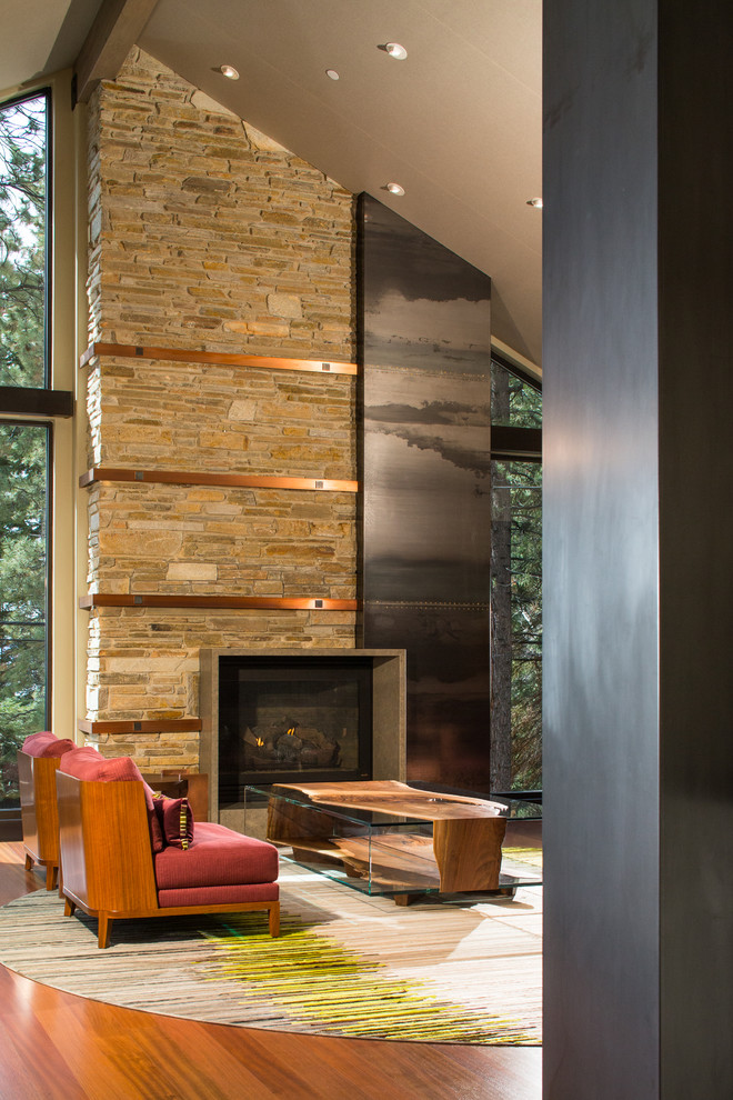 Geräumiges Modernes Wohnzimmer mit beiger Wandfarbe, braunem Holzboden, Kamin, Kaminumrandung aus Metall und braunem Boden in Sonstige