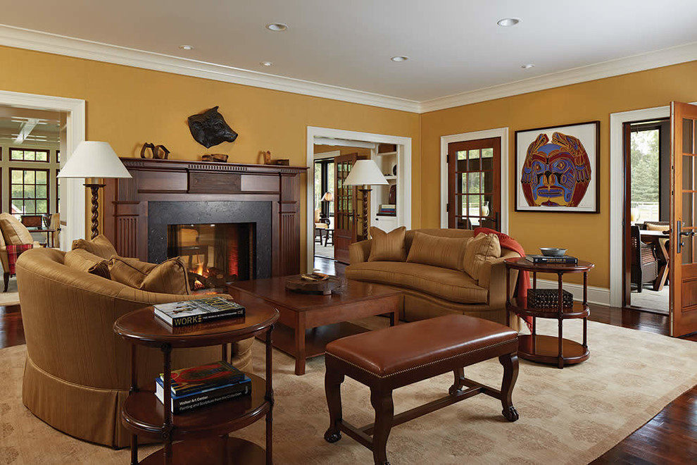 На фото: парадная, изолированная гостиная комната в классическом стиле с оранжевыми стенами, темным паркетным полом, стандартным камином и фасадом камина из дерева без телевизора с