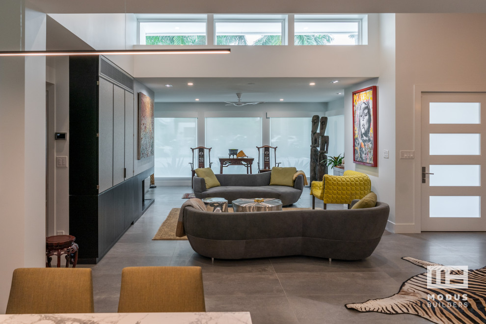 Стильный дизайн: открытая гостиная комната среднего размера в стиле ретро с белыми стенами, скрытым телевизором и серым полом - последний тренд