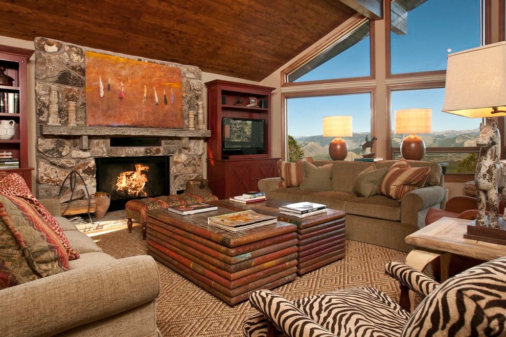 Photo of a rustic living room in Other with beige walls, carpet, a standard fireplace and a stone fireplace surround.