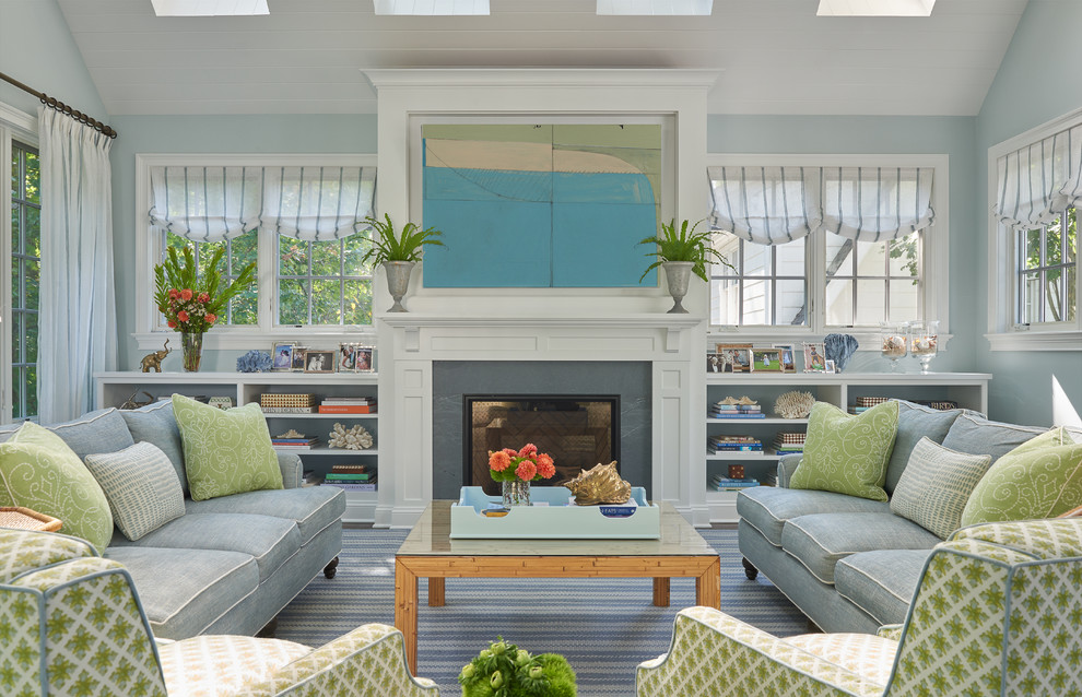 Идея дизайна: большая открытая гостиная комната в стиле неоклассика (современная классика) с с книжными шкафами и полками, синими стенами, стандартным камином, фасадом камина из дерева, скрытым телевизором, ковровым покрытием и синим полом